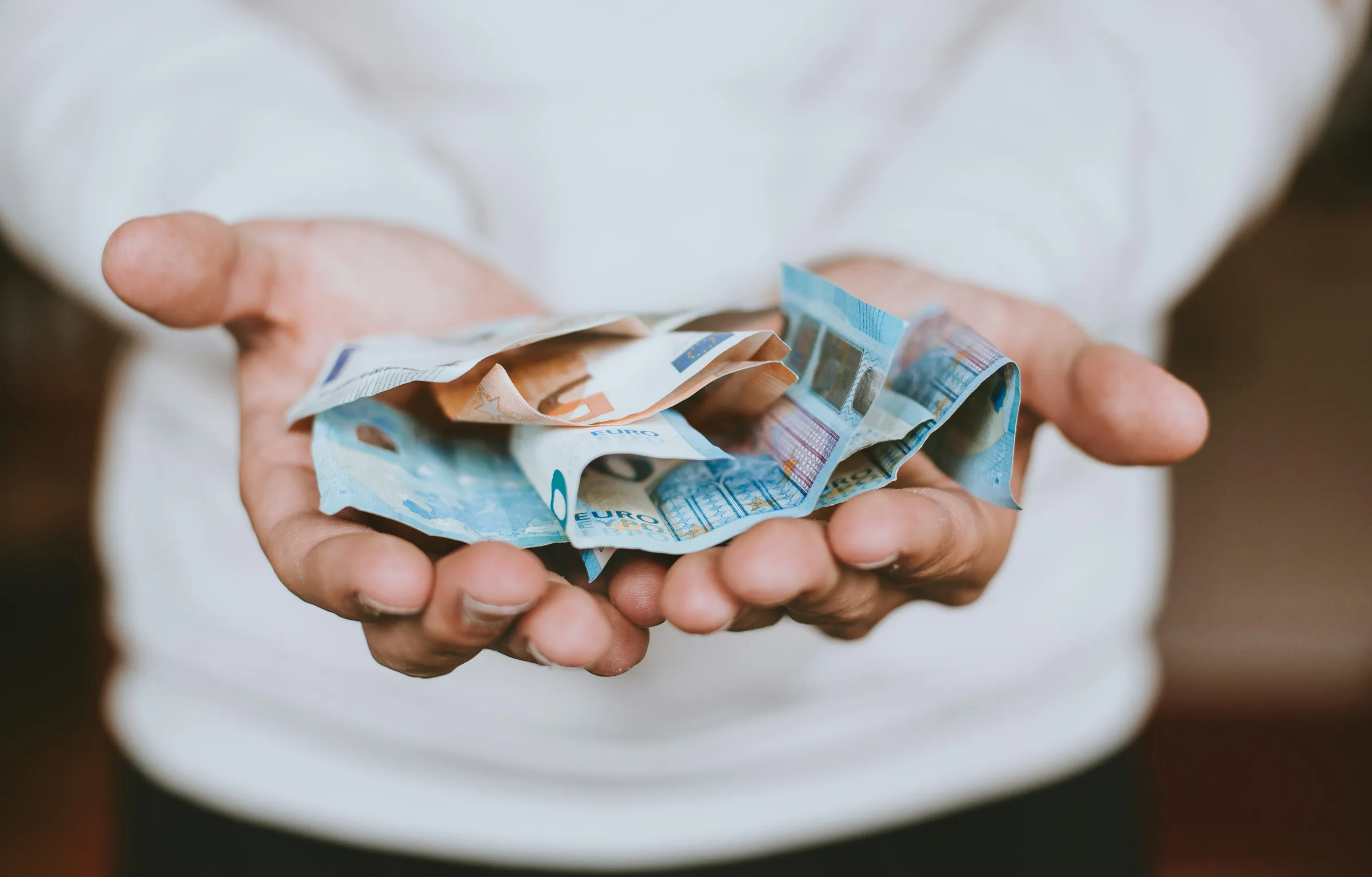 Personne tendant les mains avec des billets dedans
