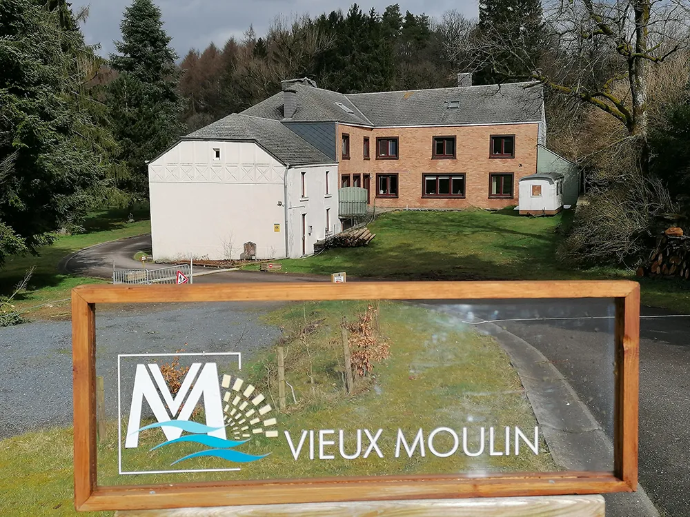 Vue sur le panneau d'accueil du Vieux Moulin. On y retrouve le logo du Vieux Moulin dessus.