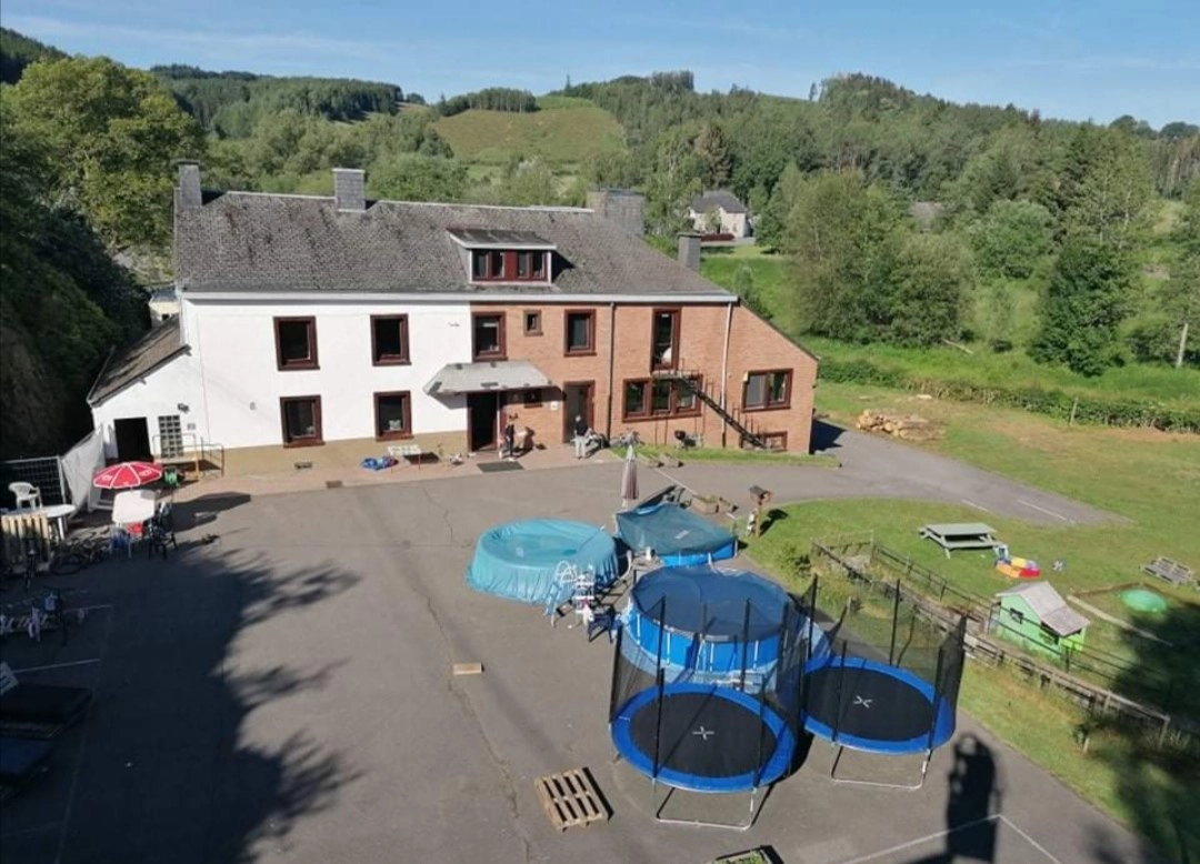 Vue sur la cour arrière du foyer du Vieux Moulin. On y voit des piscines et des trampolines.